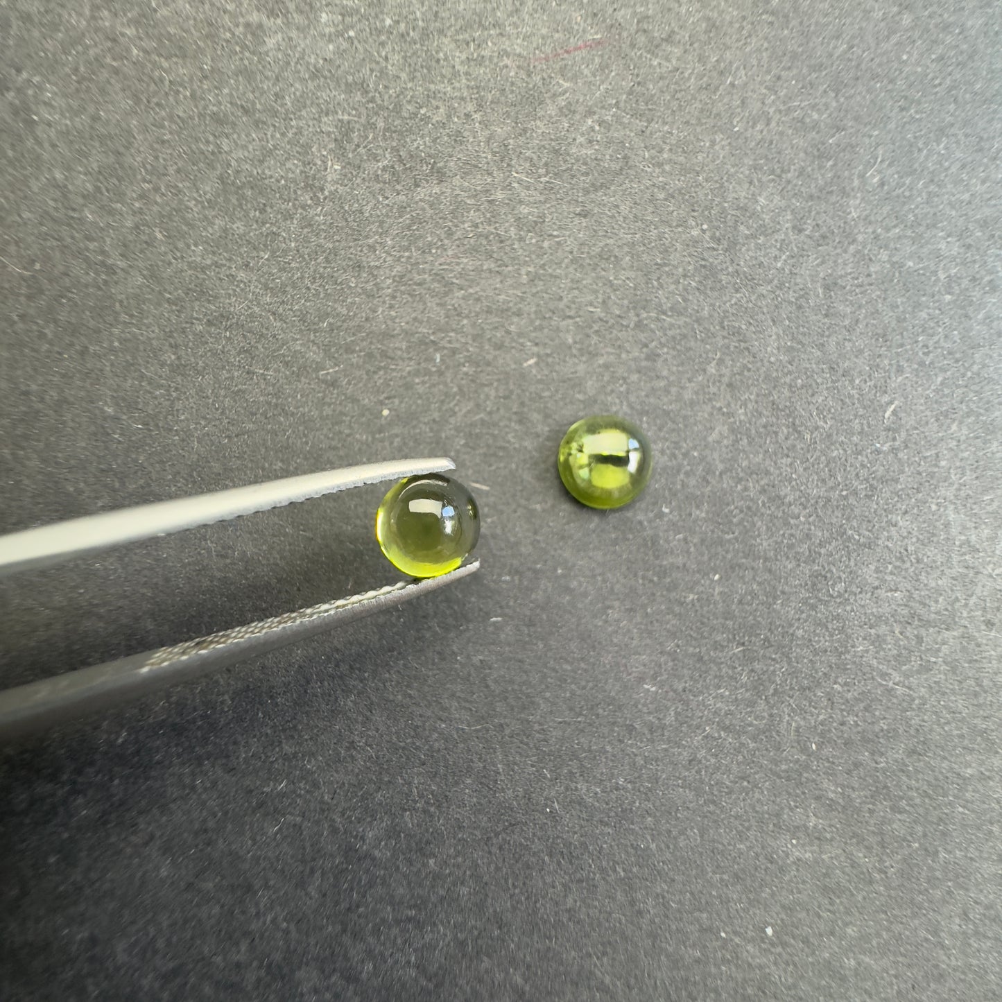 Peridot round cabochon pair, approx. 6.1mm and 5.7mm diameters, 1.85cts