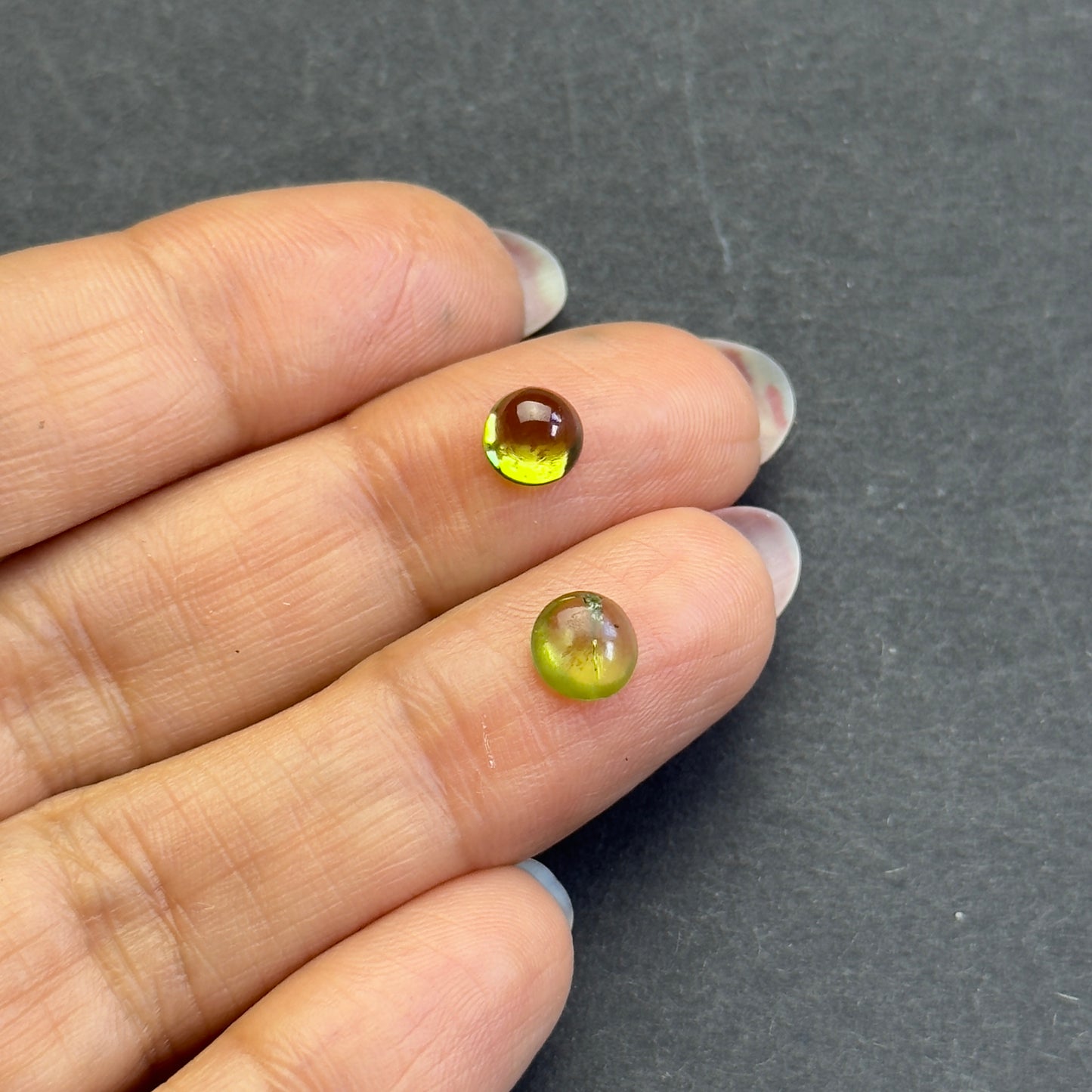 Peridot round cabochon pair, approx. 6.1mm and 5.7mm diameters, 1.85cts