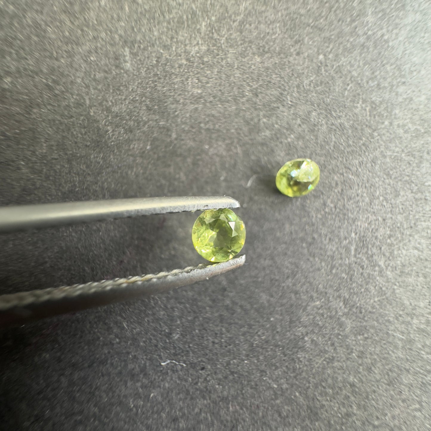 Peridot round pair, both approx. 3.3mm in diameter, 0.32cts