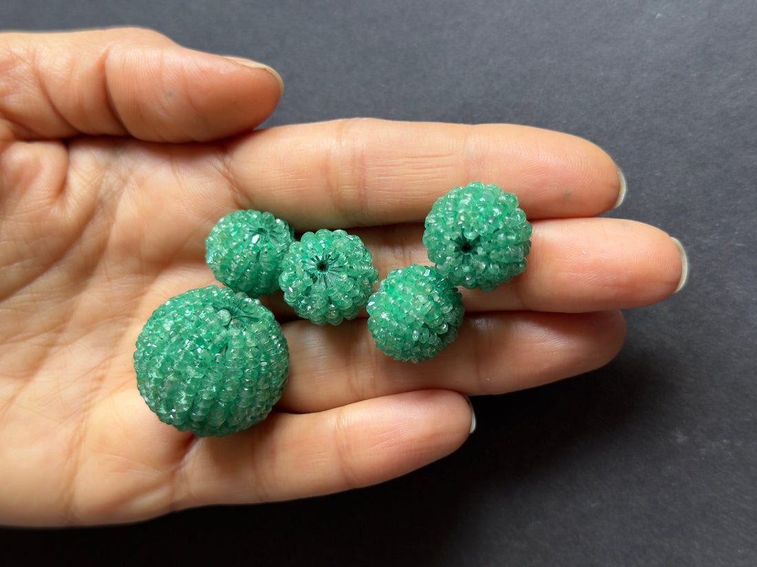 Deep green emerald pear-shaped stone with natural inclusions
