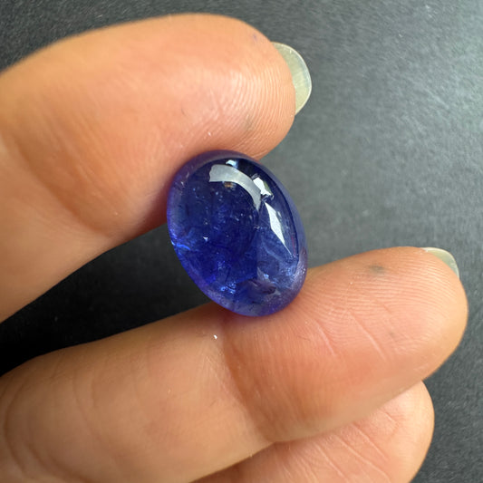 a captivating deep indigo blue oval shape with subtle white inclusions.